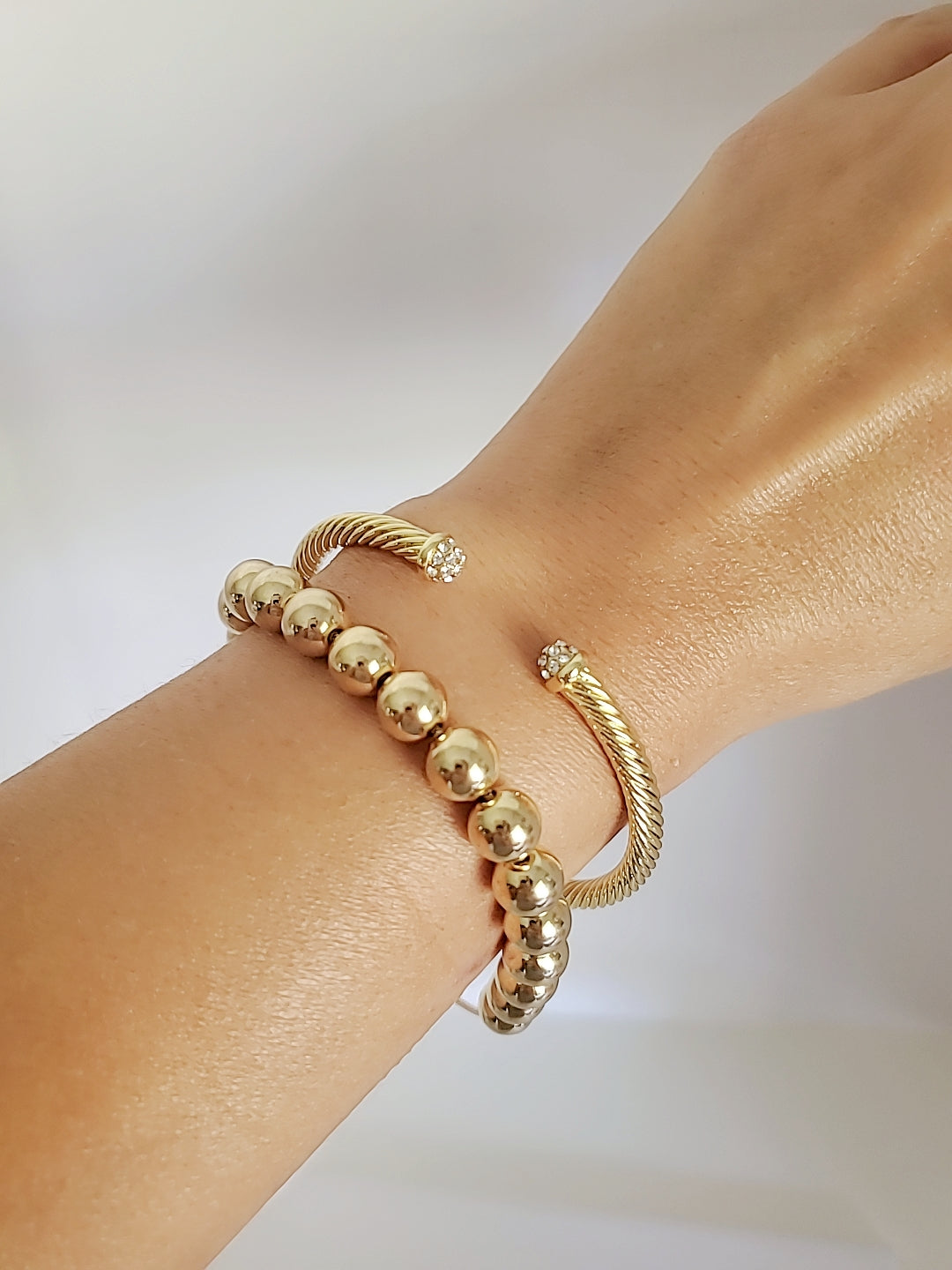 Dainty Crystals Dome Bangle in Gold and Silver with a sleek cable design and dome ends, showcasing its elegant and modern style.