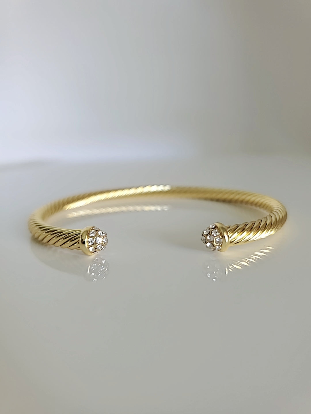 Dainty Crystals Dome Bangle in Gold and Silver with a sleek cable design and dome ends, showcasing its elegant and modern style.