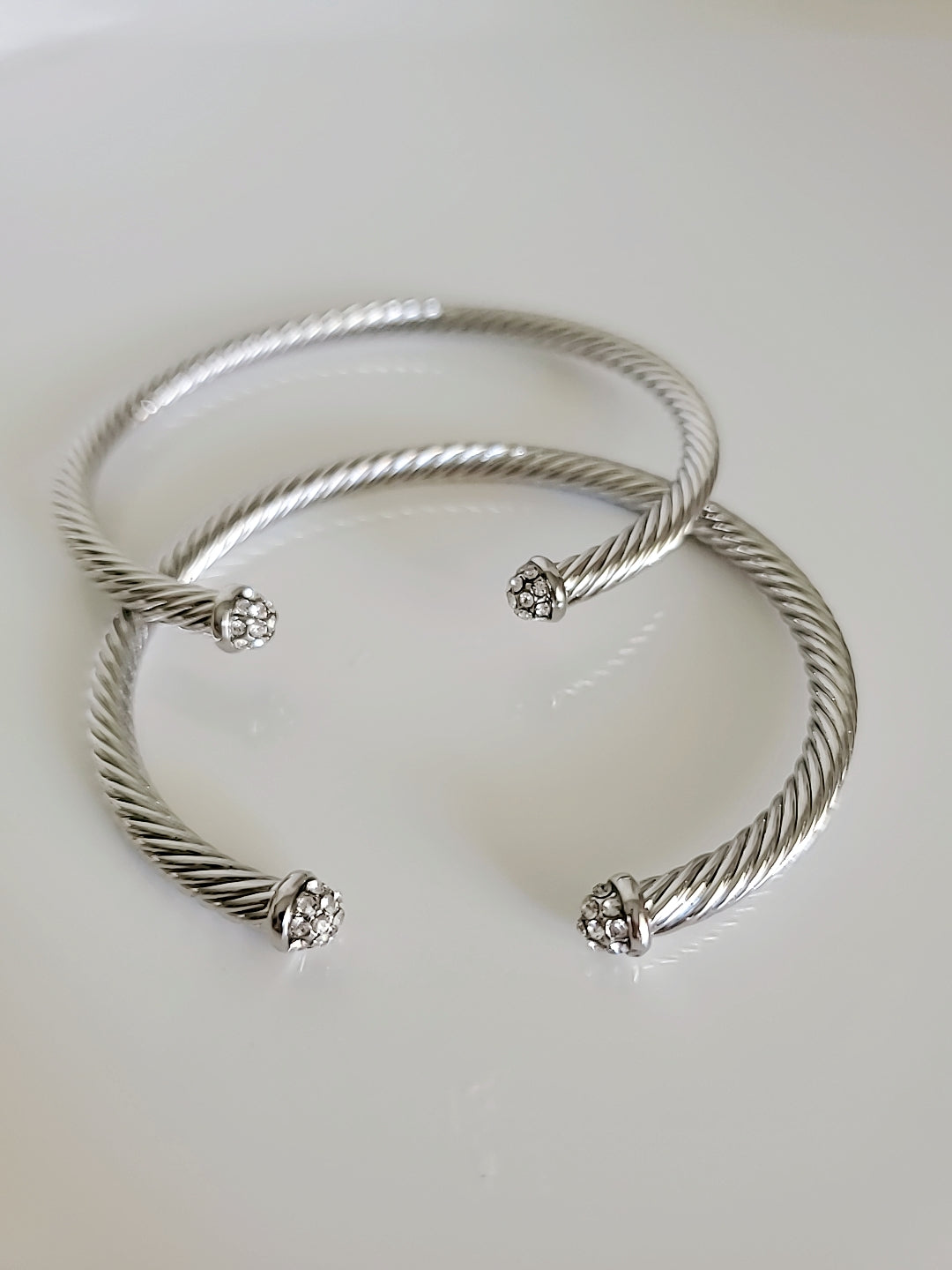 Dainty Crystals Dome Bangle in Gold and Silver with a sleek cable design and dome ends, showcasing its elegant and modern style.