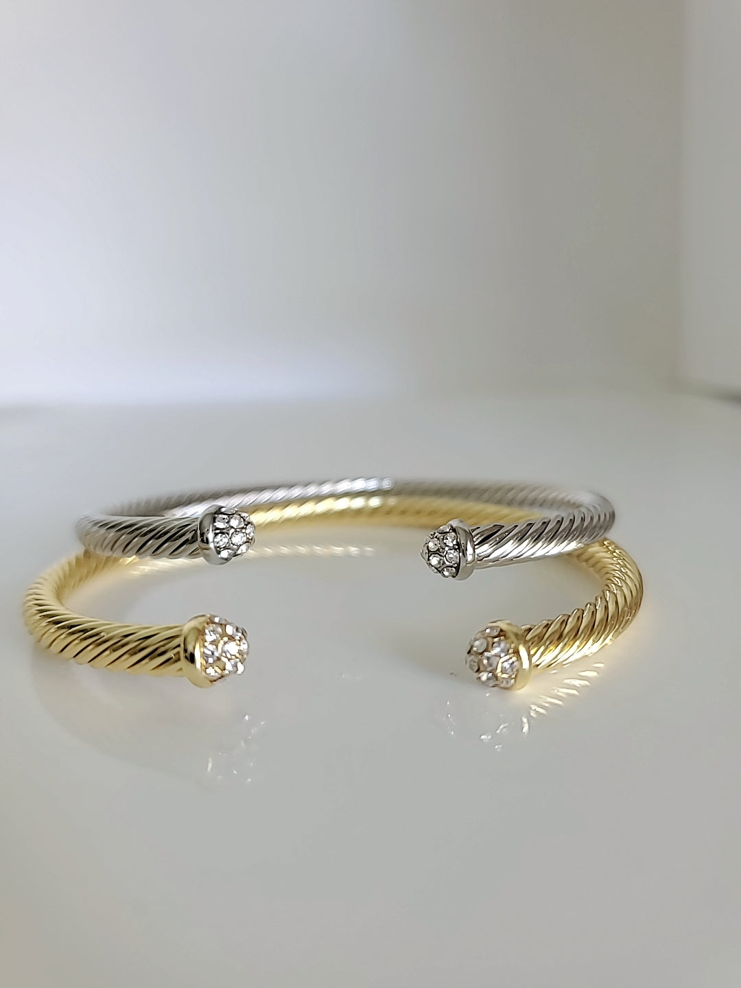 Dainty Crystals Dome Bangle in Gold and Silver with a sleek cable design and dome ends, showcasing its elegant and modern style.