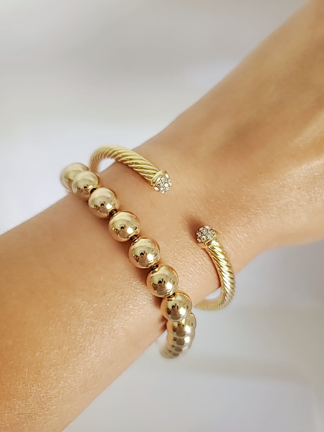Dainty Crystals Dome Bangle in Gold and Silver with a sleek cable design and dome ends, showcasing its elegant and modern style.