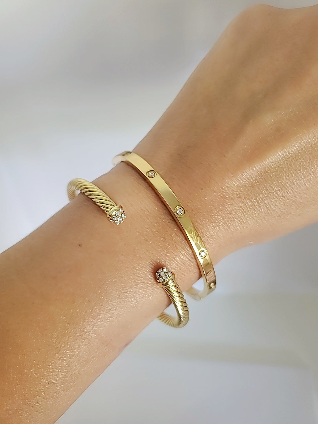 Dainty Crystals Dome Bangle in Gold and Silver with a sleek cable design and dome ends, showcasing its elegant and modern style.