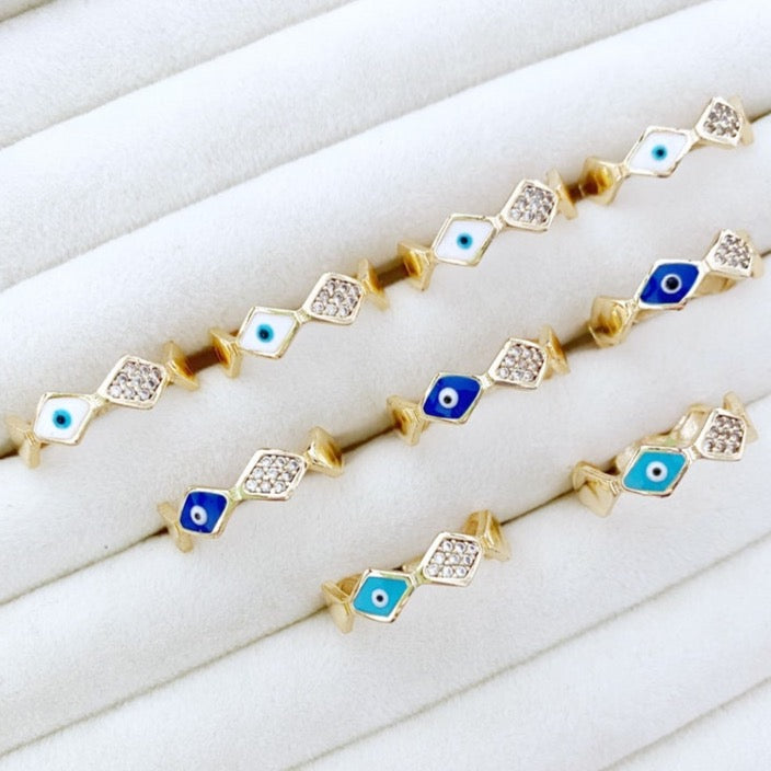 Dainty adjustable gold evil eye rings featuring white and blue beads, designed for stylish protection and versatility.