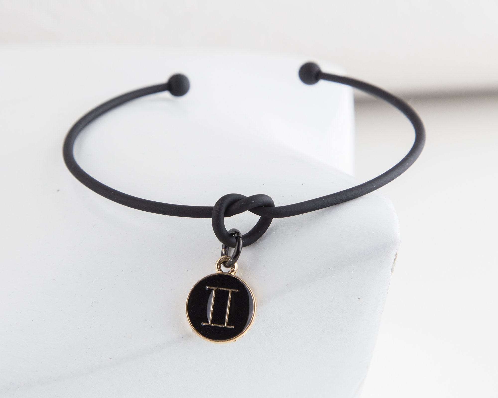 Dainty Knot Bracelet featuring a black metal wire knot design and a zodiac symbol charm, adjustable size for a perfect fit.