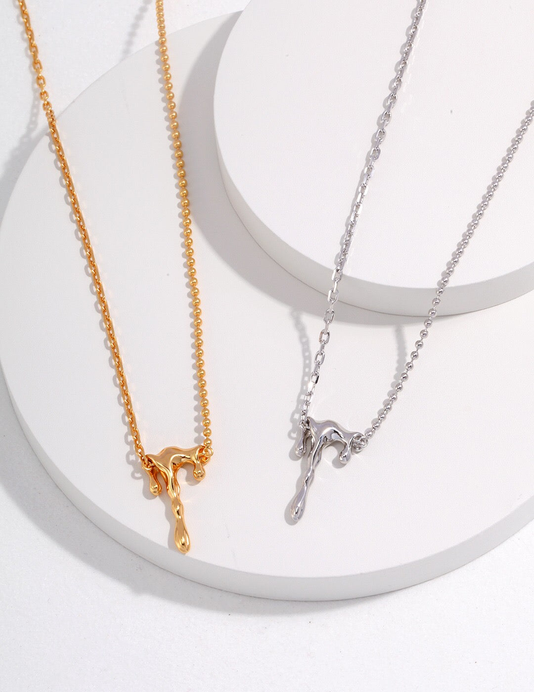 A close-up of the Dainty Lava Style Necklace showcasing its sterling silver and gold vermeil craftsmanship, featuring a delicate pendant.