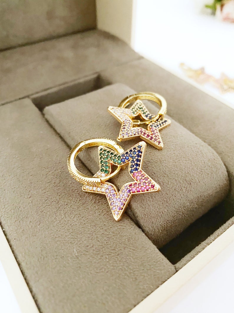 A pair of handmade dangle earrings featuring rainbow zircon stones with heart and star charms, elegantly designed in gold color.