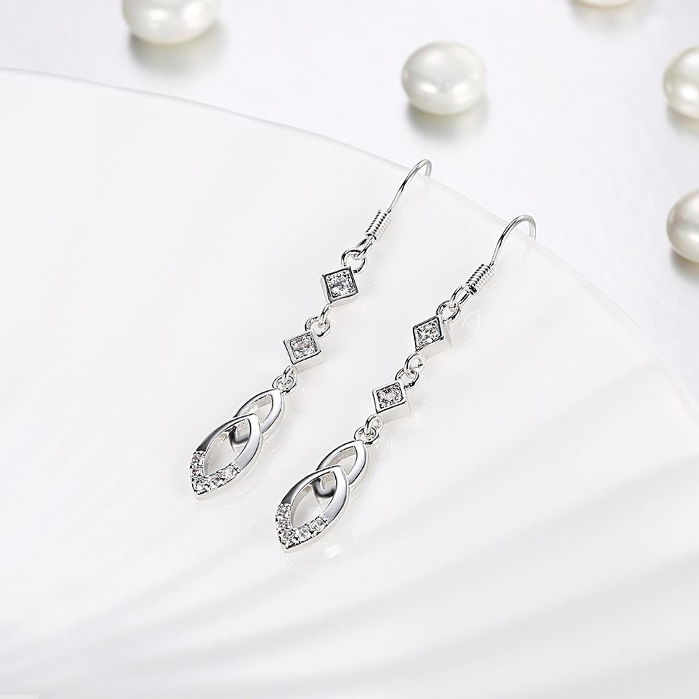 Elegant dangling infinity drop earrings made with certified crystals and 18K white gold plating, showcasing a sophisticated design.