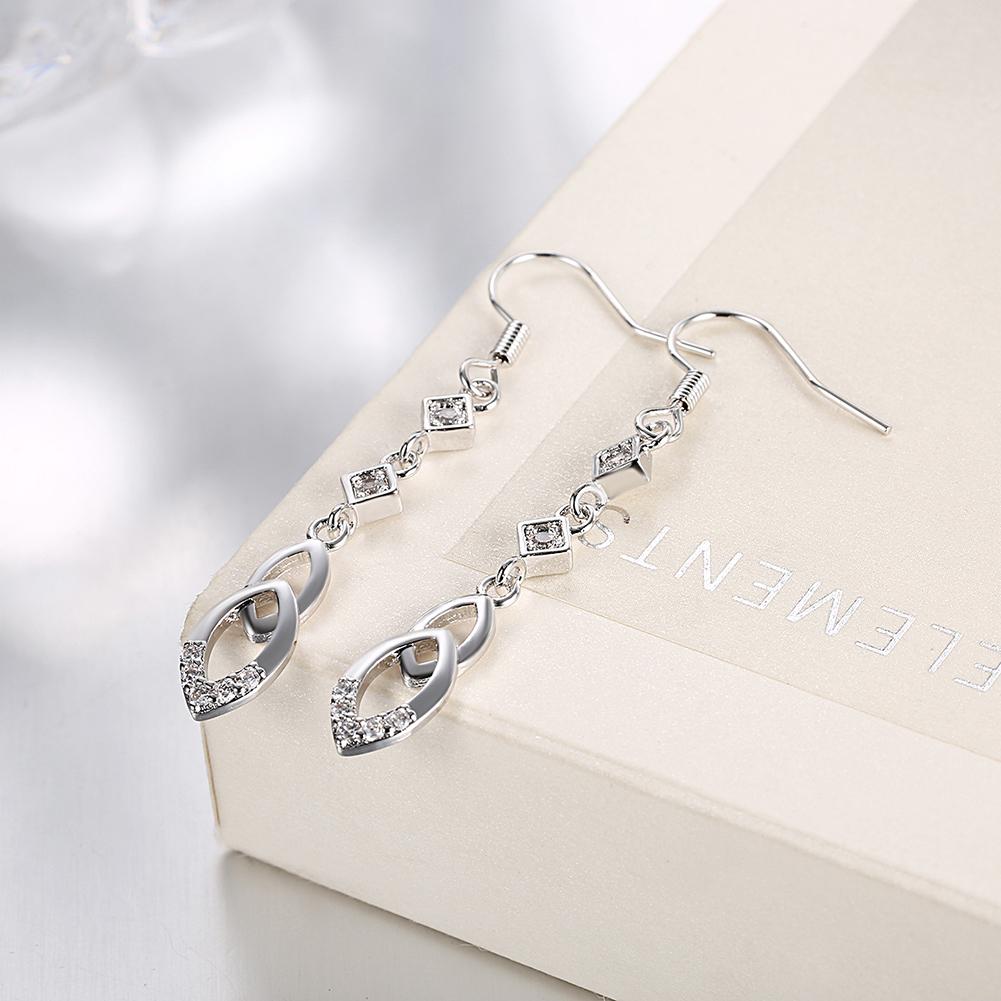 Elegant dangling infinity drop earrings made with certified crystals and 18K white gold plating, showcasing a sophisticated design.