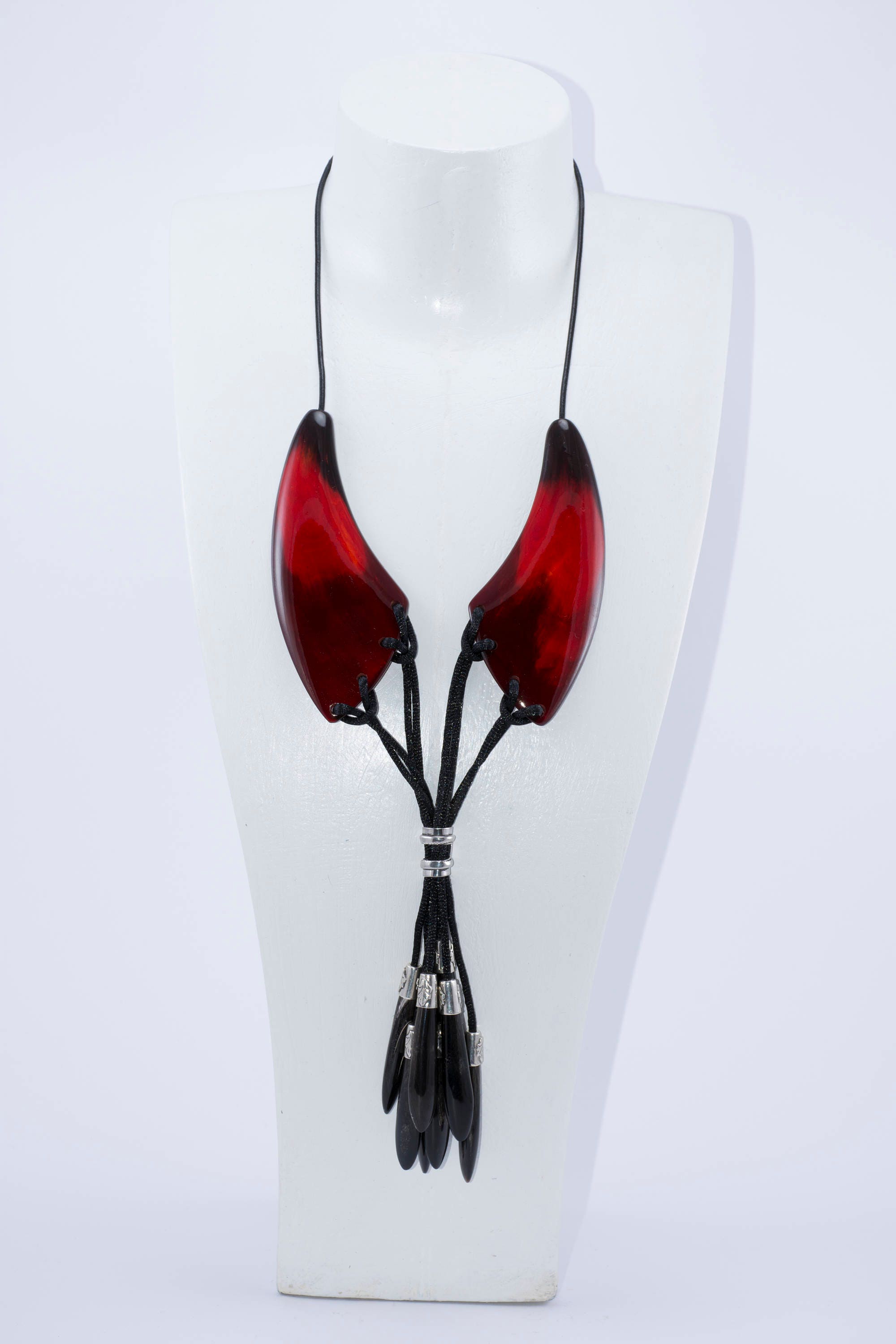 A beautiful dark red necklace made from natural horn with silver caps and teardrop-shaped endings, showcasing its unique craftsmanship.