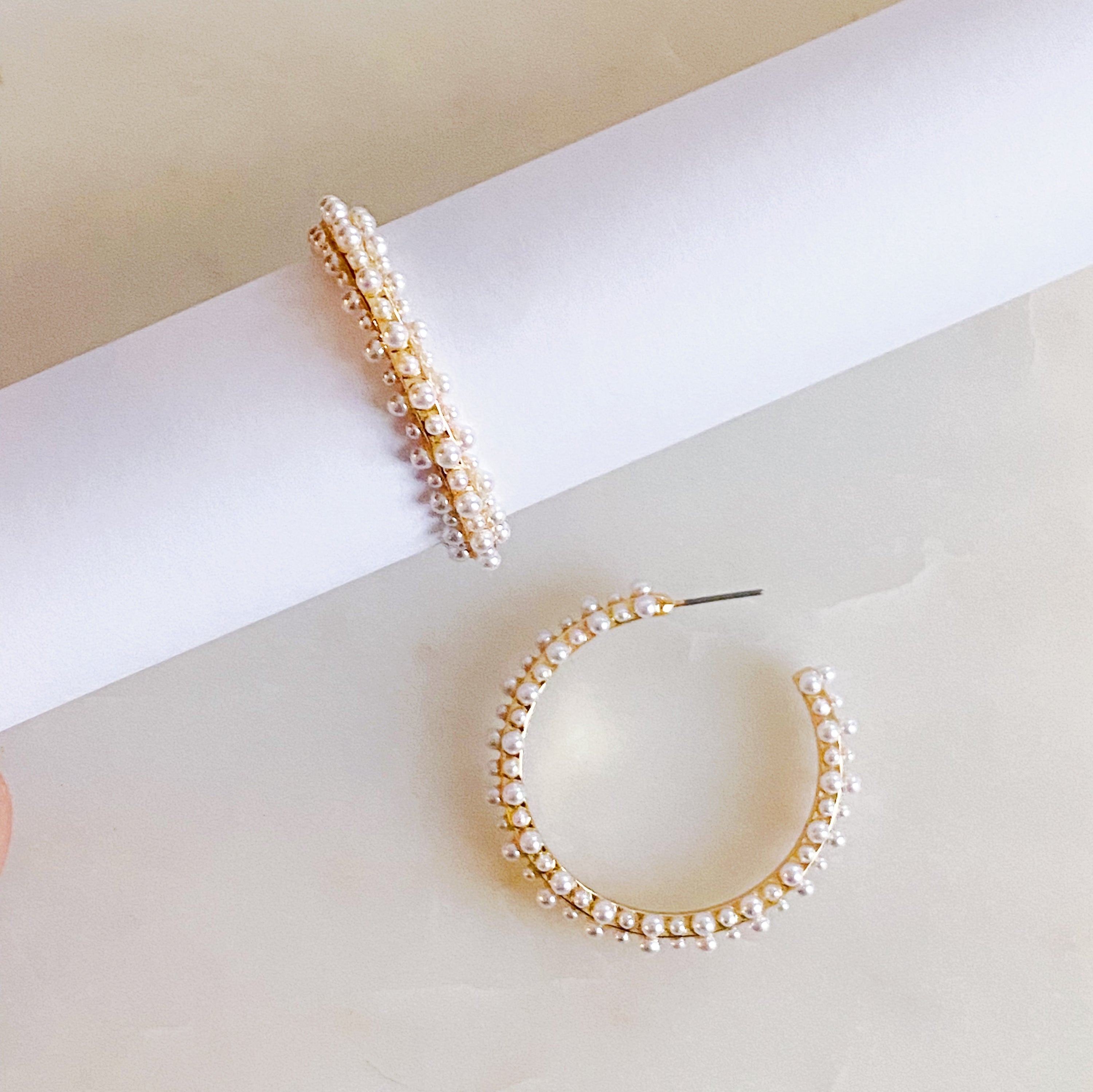 Delicate Pearl Deco Hoop Earrings featuring small pearl beads arranged around a gold hoop, showcasing elegance and sophistication.