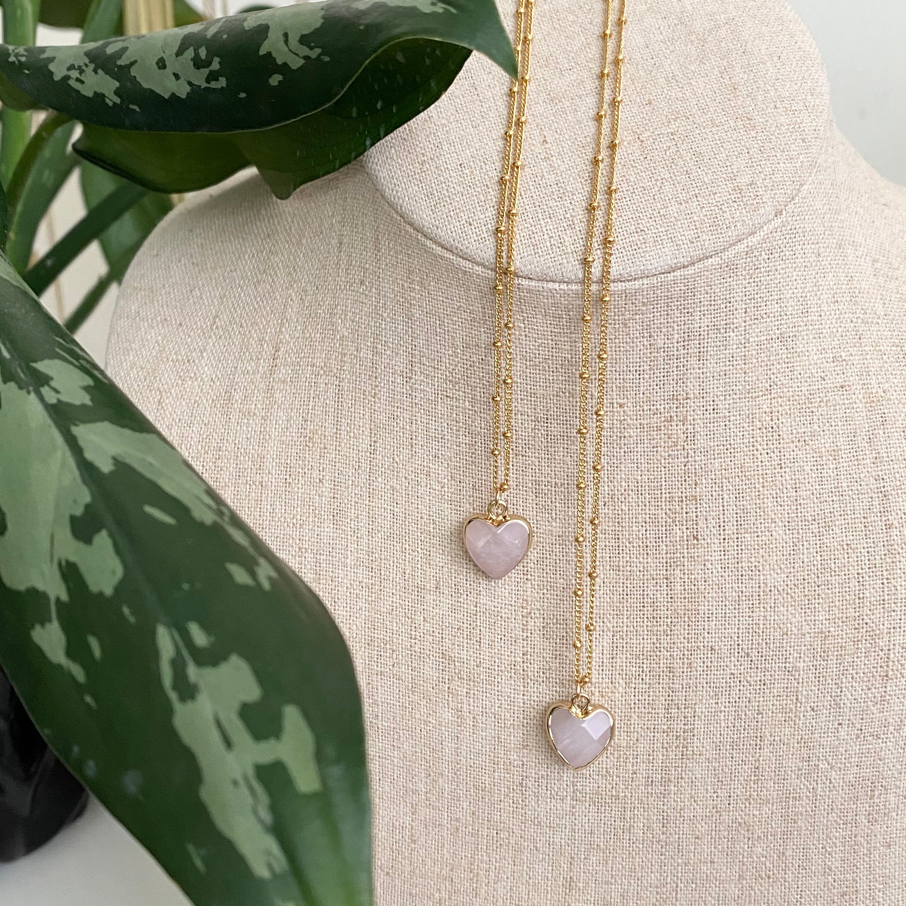 Delicate rose quartz heart pendant on a 14K gold filled ball chain, showcasing its elegant design and soft pink hue.