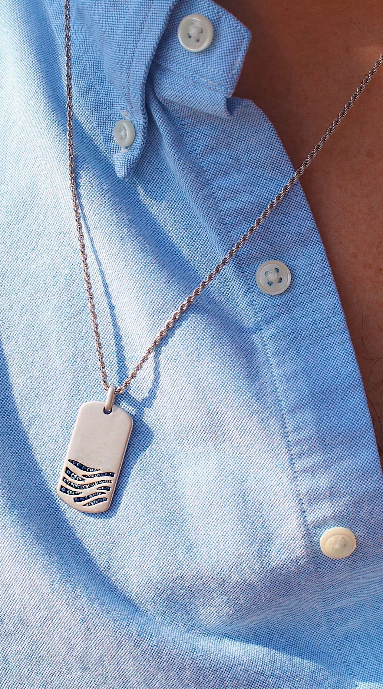 Deep Blue Sea Sterling Silver Tag with blue sapphire and topaz stones, featuring ocean wave motifs and a classic rope chain.