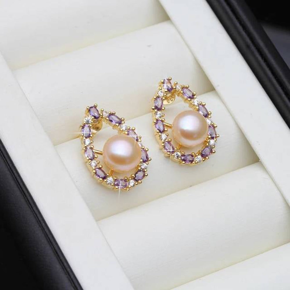 Designer oval earrings featuring genuine freshwater pearls and purple simulated diamonds, showcasing elegance and style.