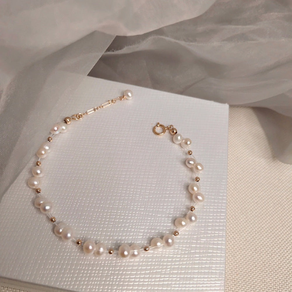 A luxurious designer bracelet featuring genuine white freshwater pearls clustered together with elegant gold accents, adjustable length for a perfect fit.