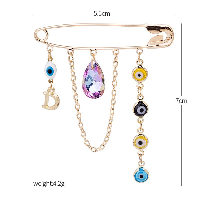 A stylish brooch featuring a devil eye design with water drop accents and tassels, made from durable alloy.