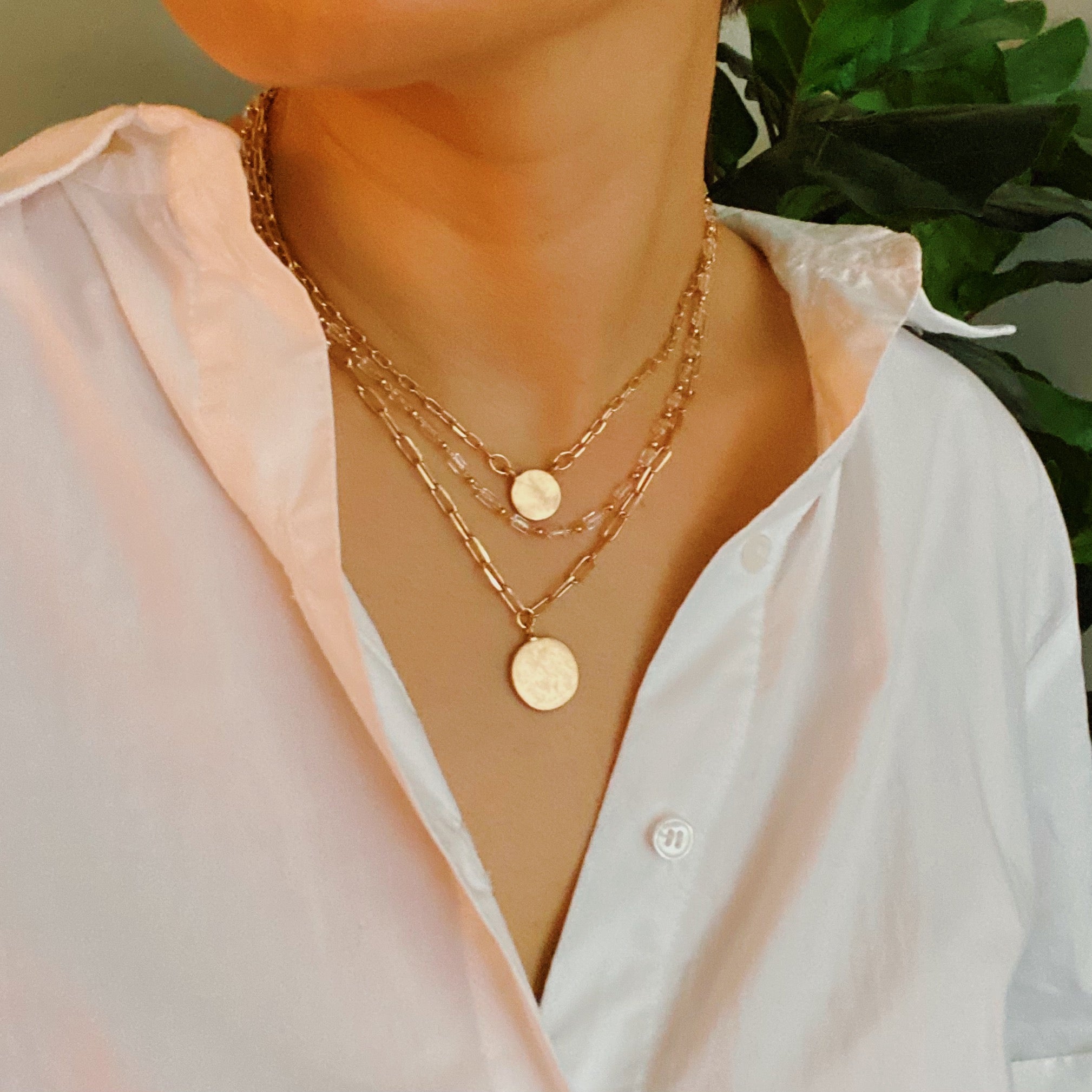 A stylish set of three necklaces featuring disc pendants and beaded designs, perfect for layering and versatile fashion.