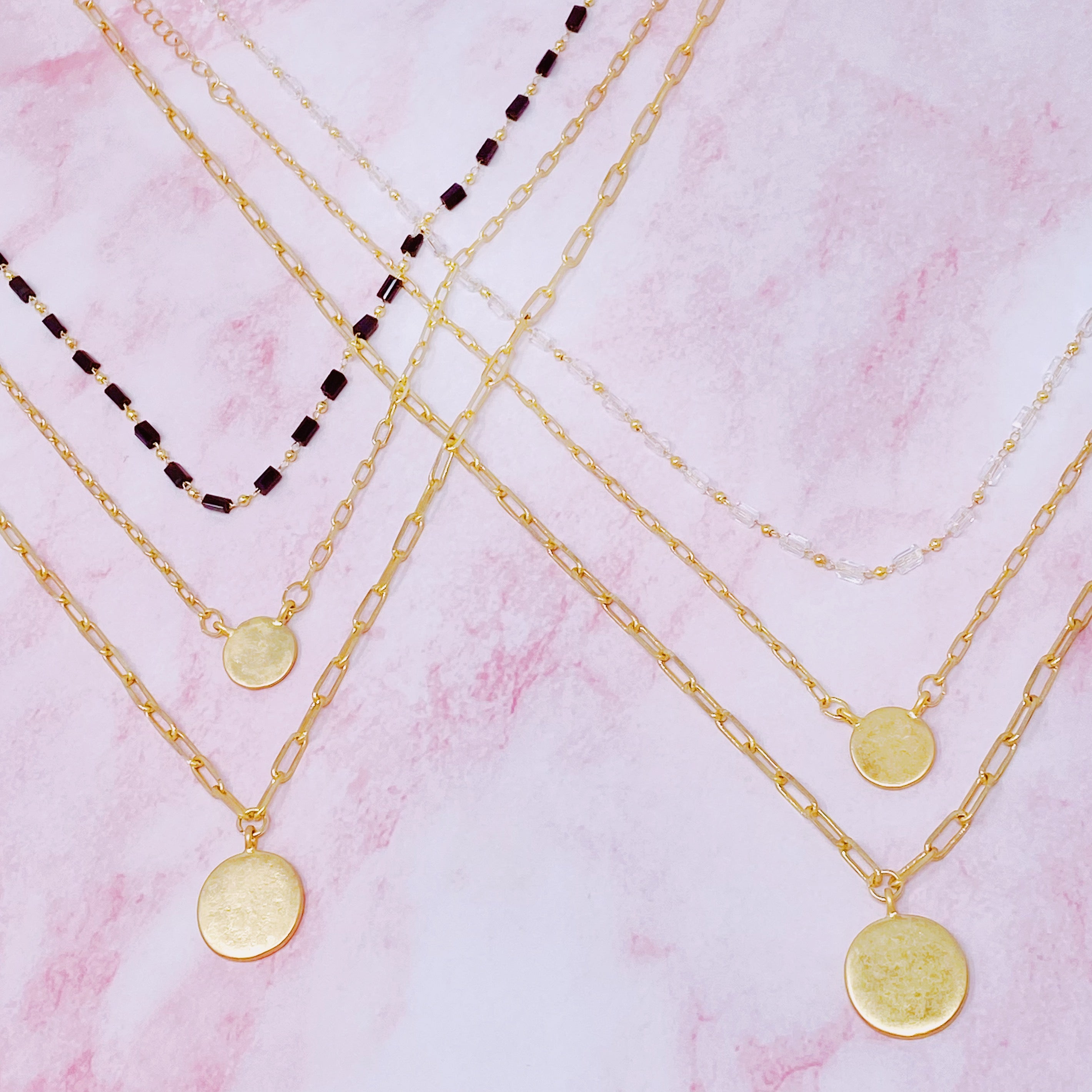A stylish set of three necklaces featuring disc pendants and beaded designs, perfect for layering and versatile fashion.