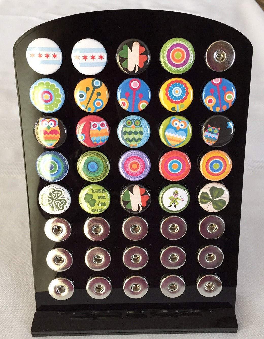 Ginger Snap Jewelry Display featuring 32 customizable ArtPopper snaps, showcasing various designs and colors.