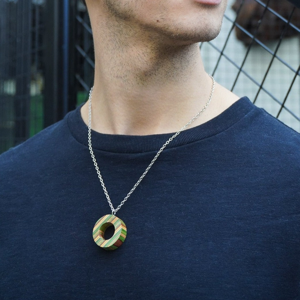 A unique Donut Eco Friendly Recycled Skateboard Necklace featuring vibrant colors and patterns, handcrafted from upcycled skateboards with a stainless steel chain.