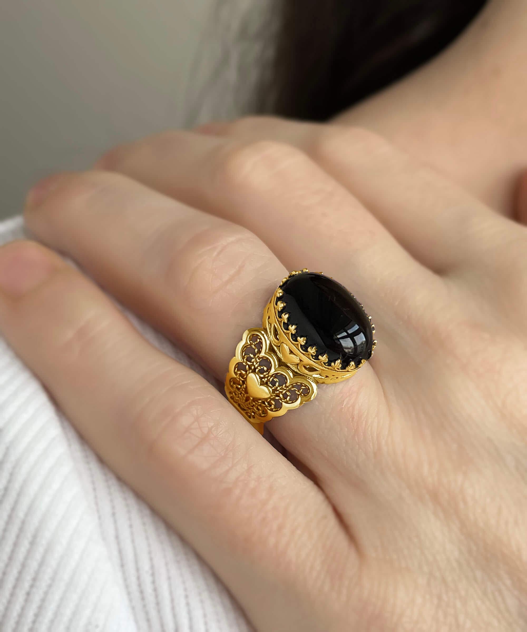 Elegant gold plated ring featuring double heart design with black onyx gemstone, beautifully crafted in filigree art style.