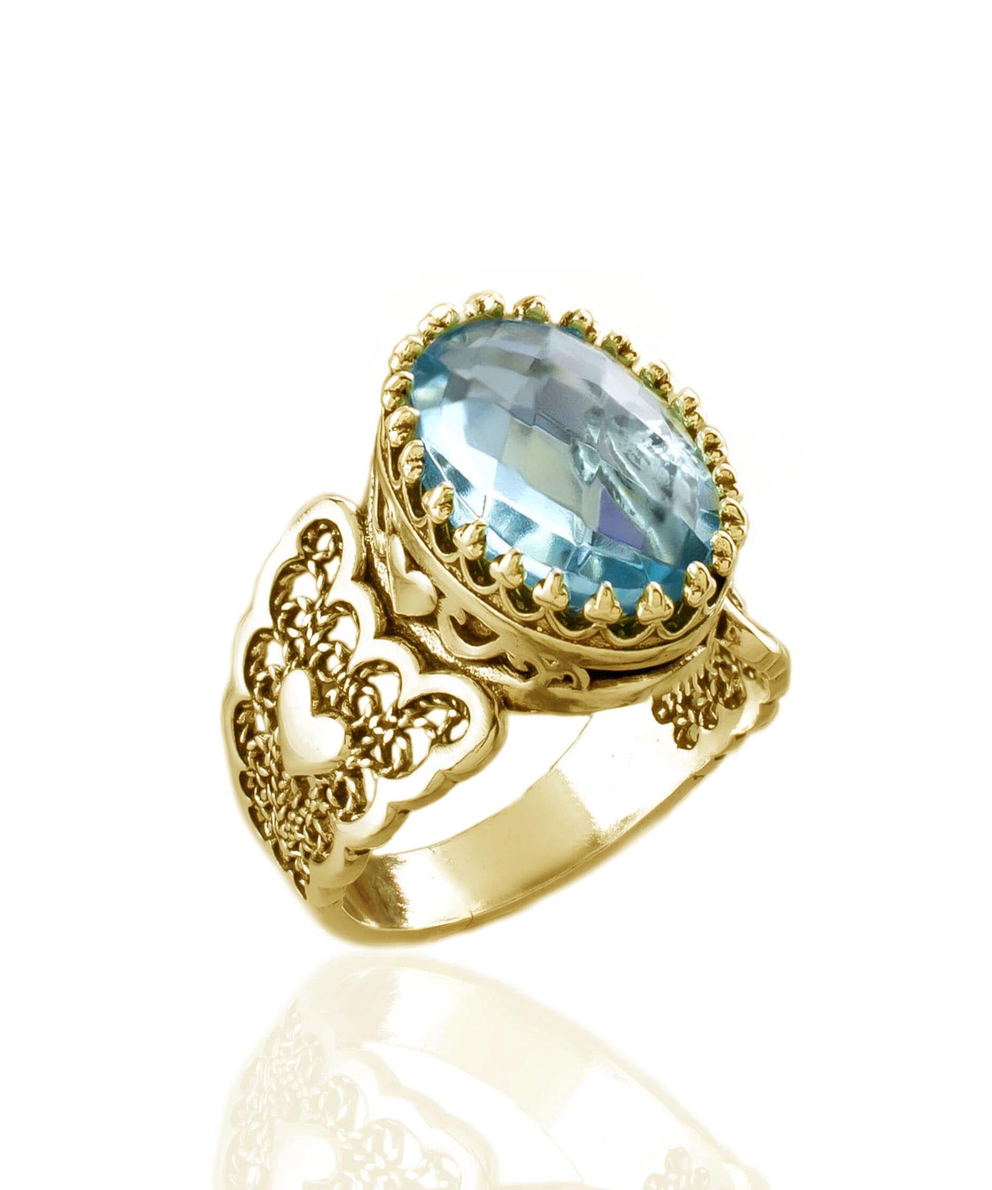 A stunning gold plated ring featuring a double heart design with a sky blue topaz gemstone, showcasing intricate filigree art.