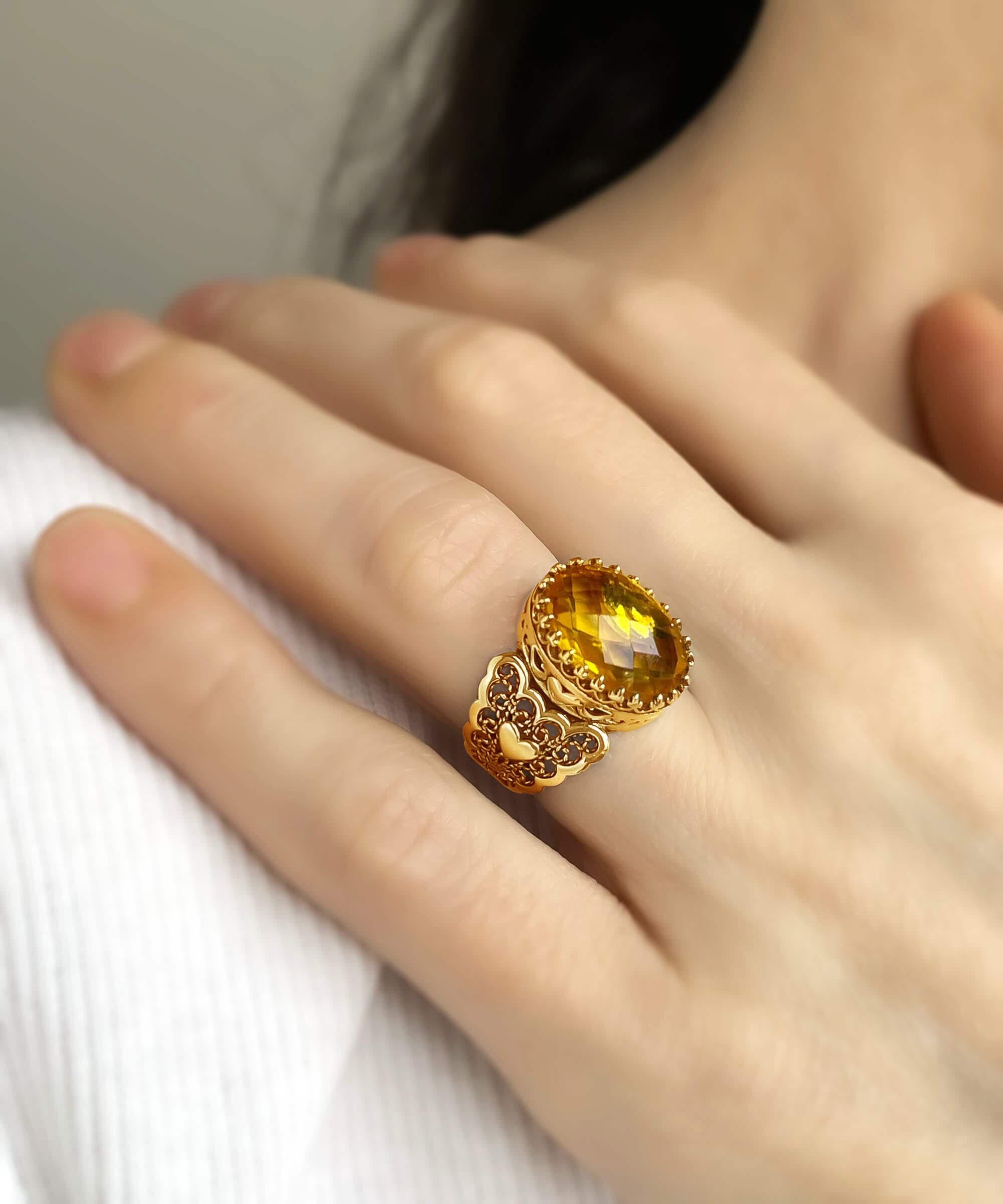 A beautiful gold plated ring featuring a double heart design with citrine gemstones, showcasing intricate filigree art.