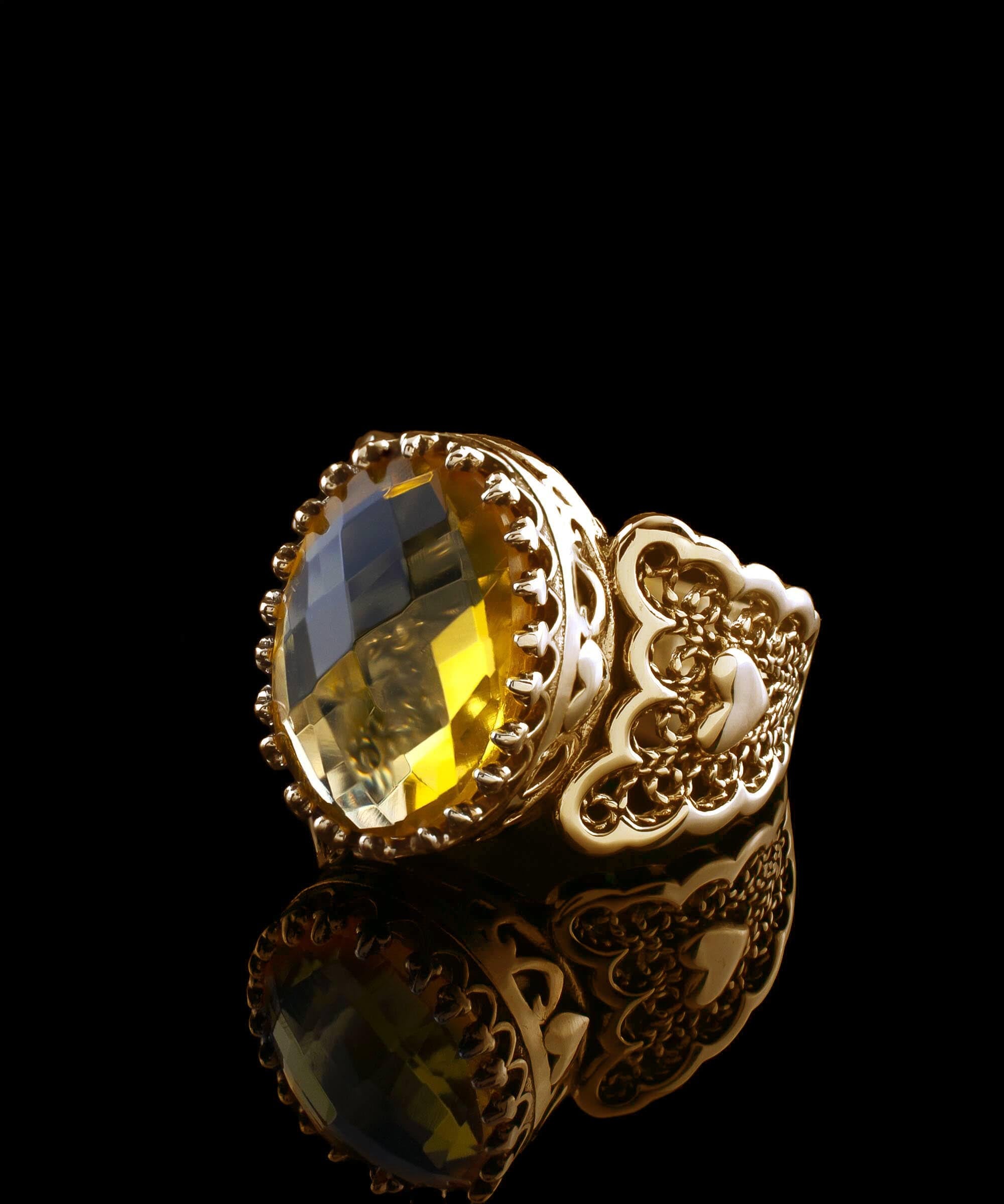 A beautiful gold plated ring featuring a double heart design with citrine gemstones, showcasing intricate filigree art.