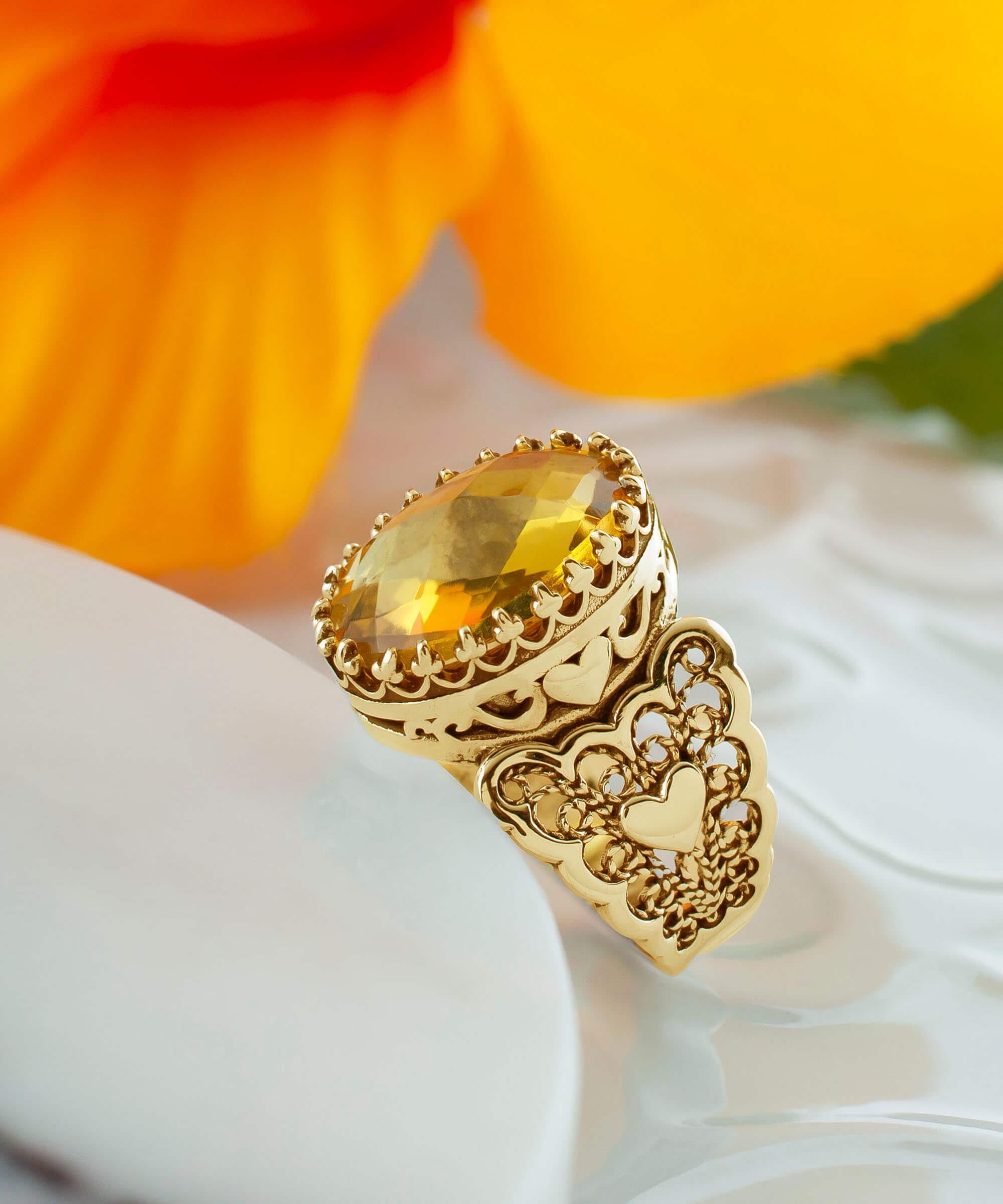 A beautiful gold plated ring featuring a double heart design with citrine gemstones, showcasing intricate filigree art.