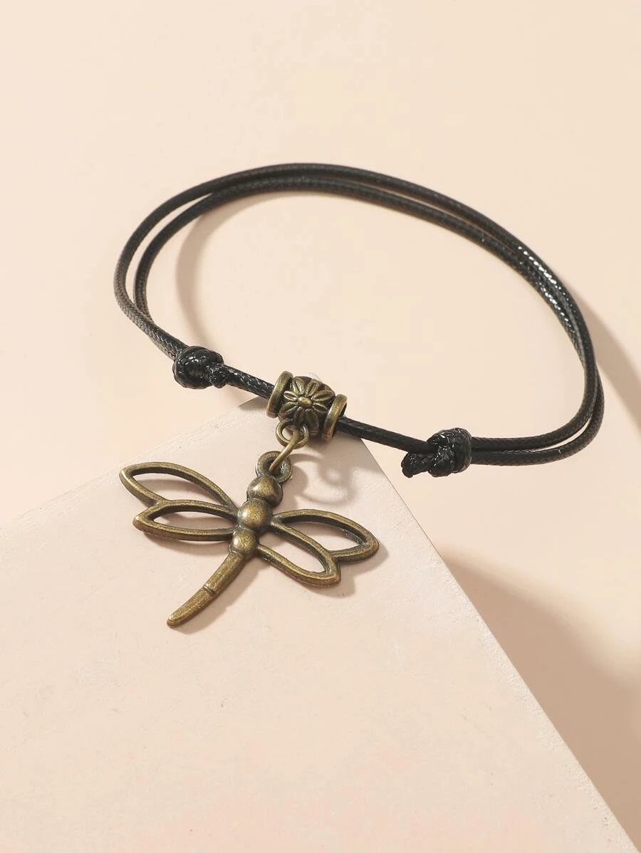A stylish Dragonfly Cham Anklet featuring an antique bronze dragonfly charm on a black adjustable cord, perfect for boho fashion.