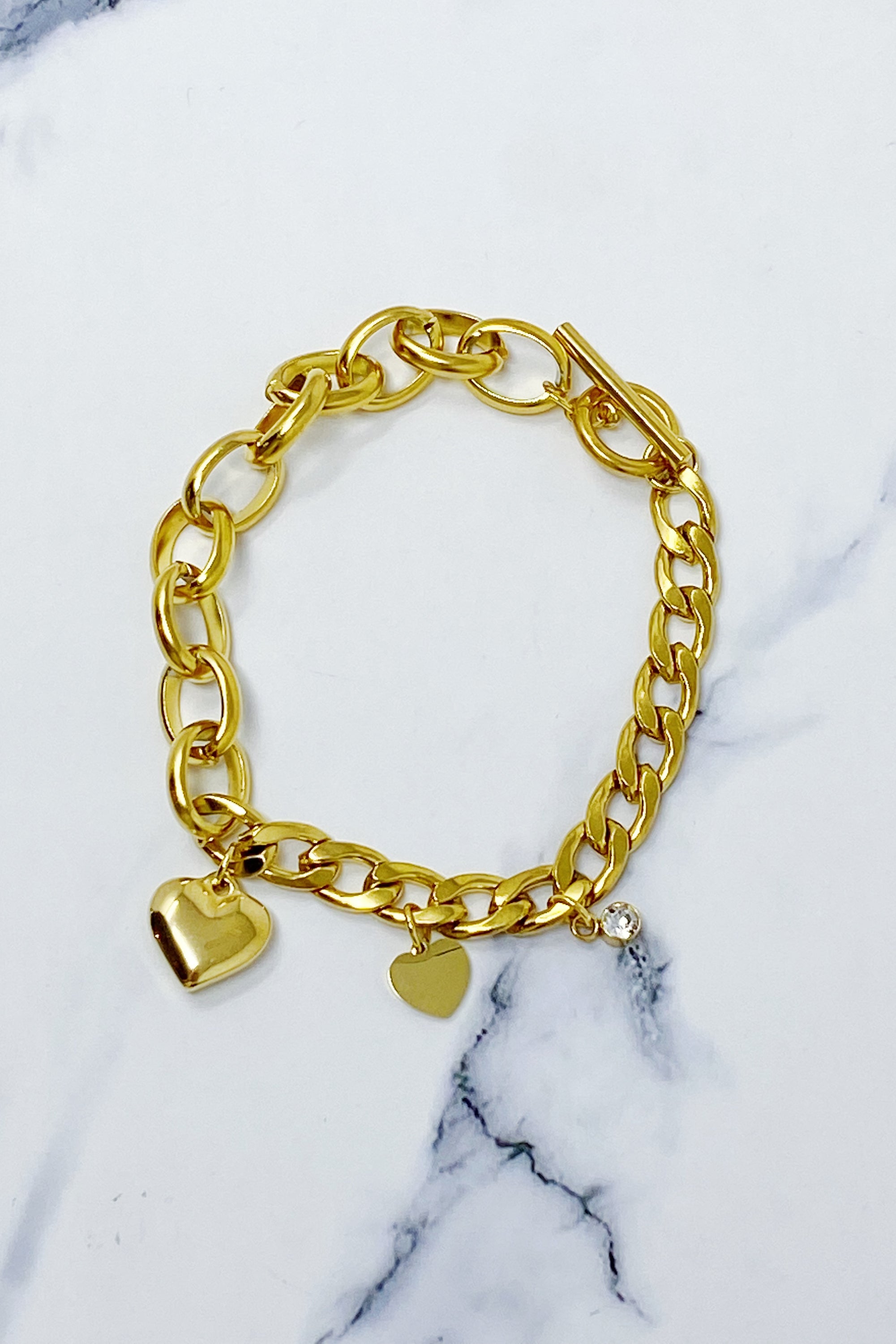 Duo Chain Charm Heart Bracelet featuring toggle closure and three unique charms, crafted from 18k gold plated stainless steel.