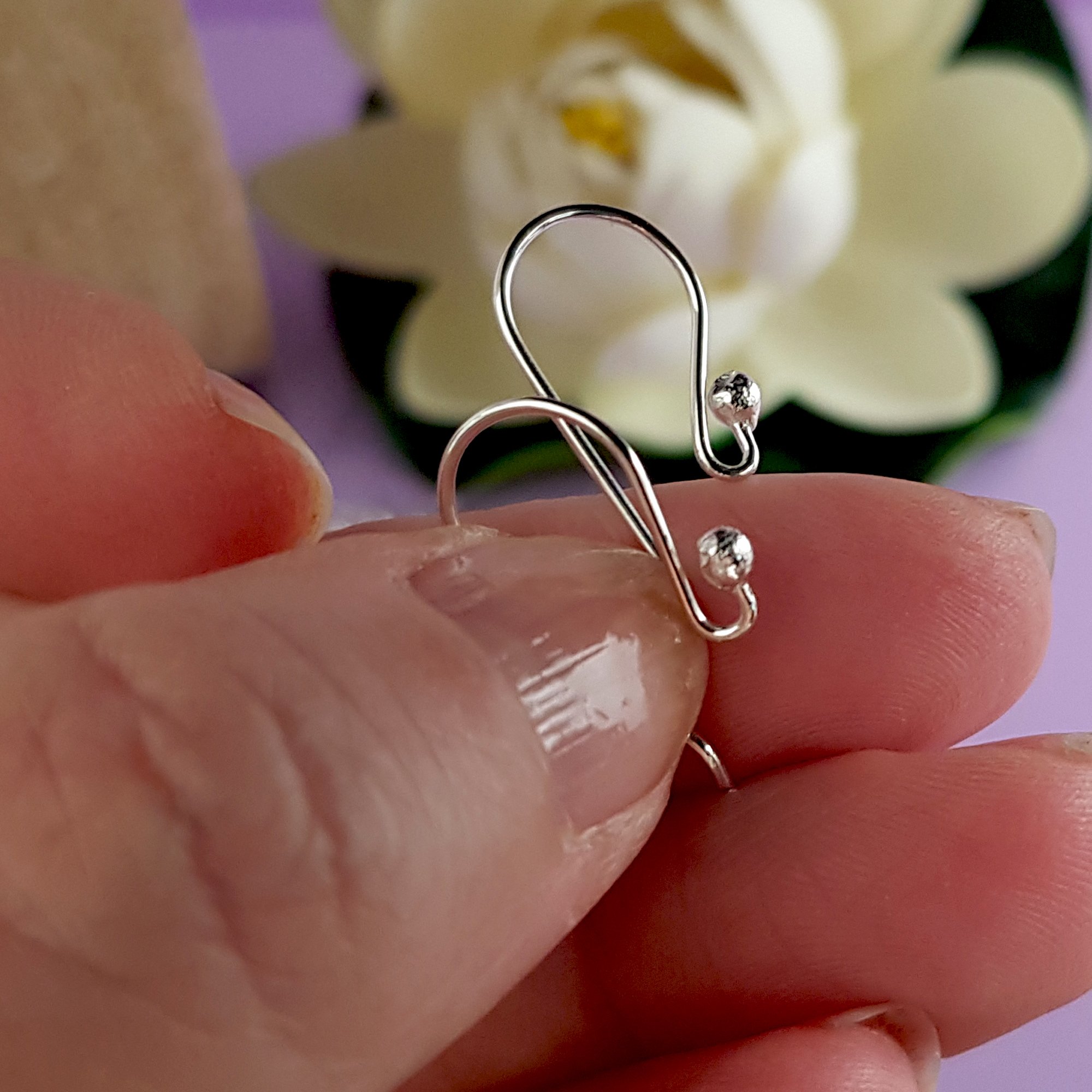 A pack of 10 pairs of handmade sterling silver earring hooks, showcasing their polished finish and 2.3 mm ball design for easy earring attachment.