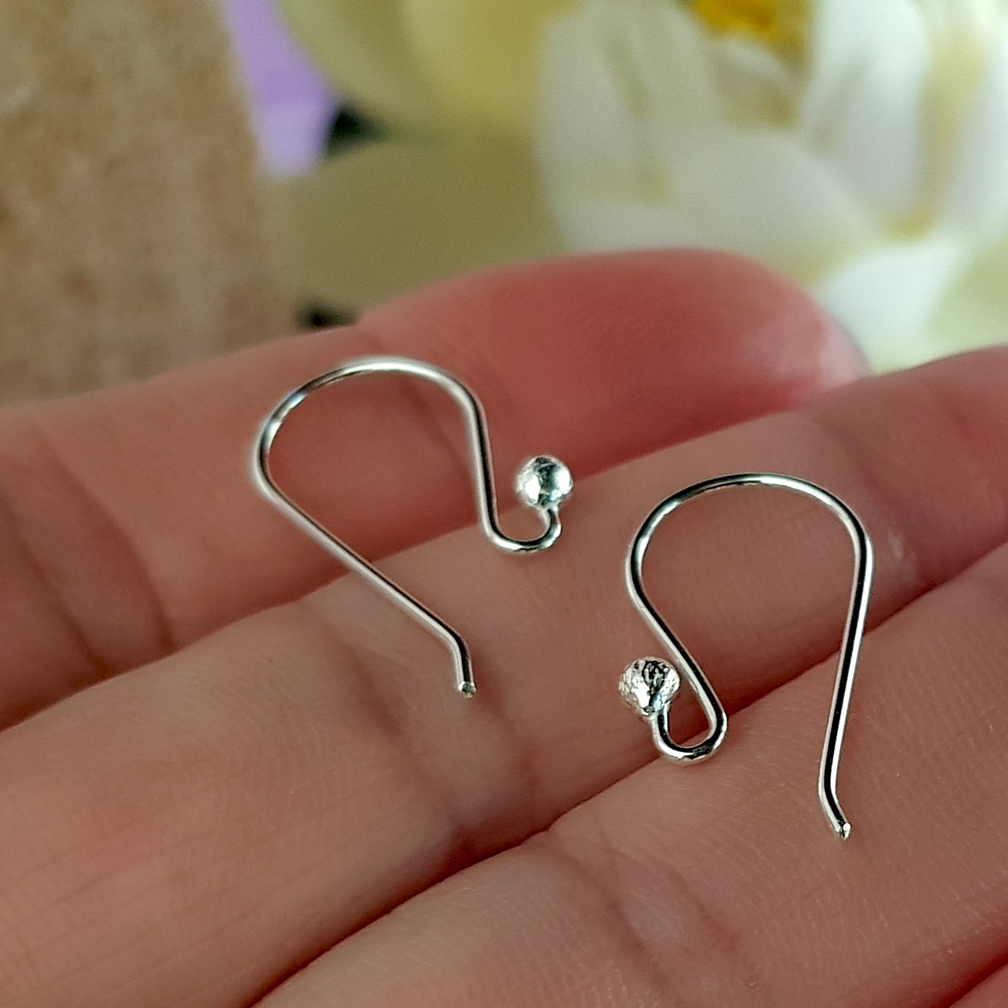 A pack of 10 pairs of handmade sterling silver earring hooks, showcasing their polished finish and 2.3 mm ball design for easy earring attachment.