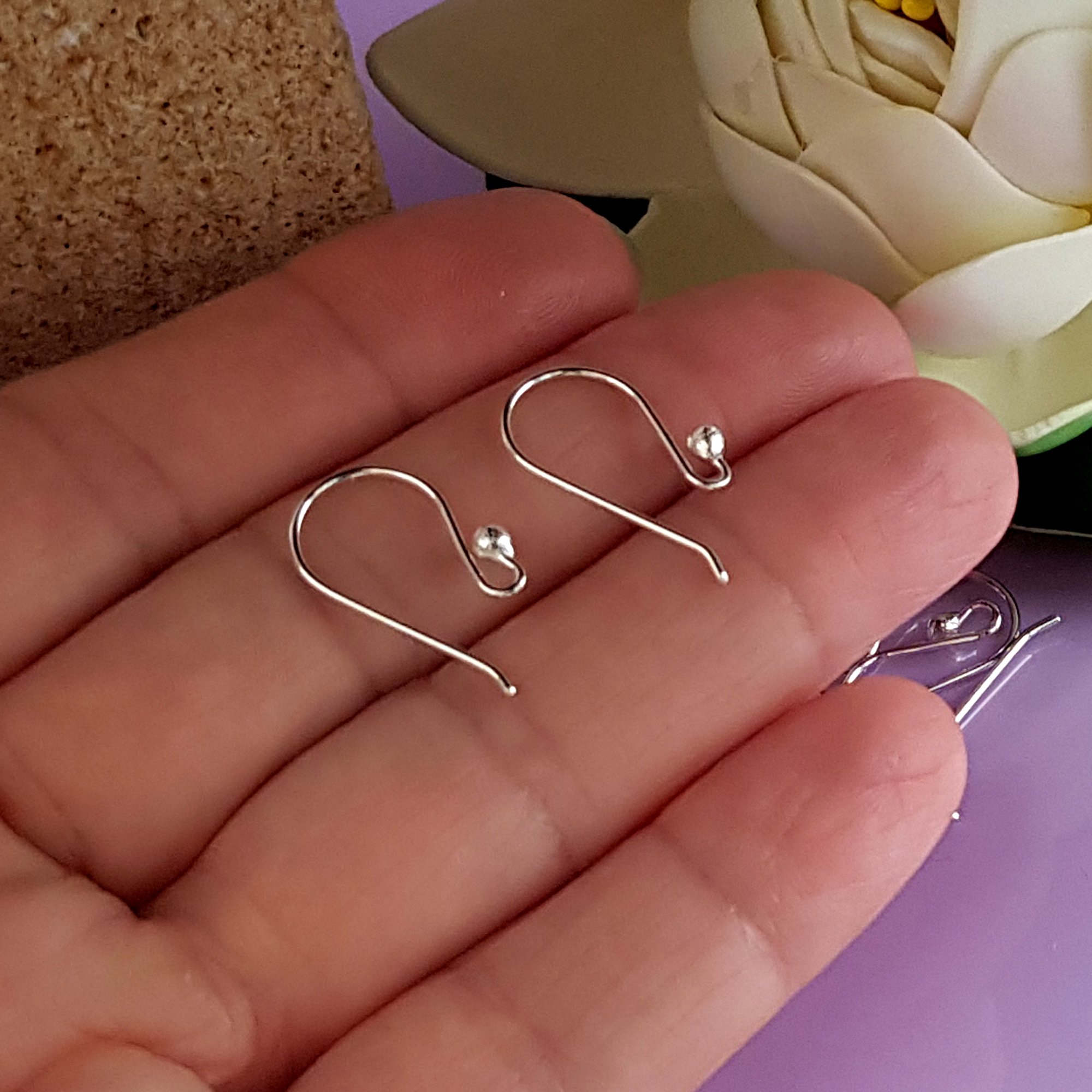 A pack of 10 pairs of handmade sterling silver earring hooks, showcasing their polished finish and 2.3 mm ball design for easy earring attachment.