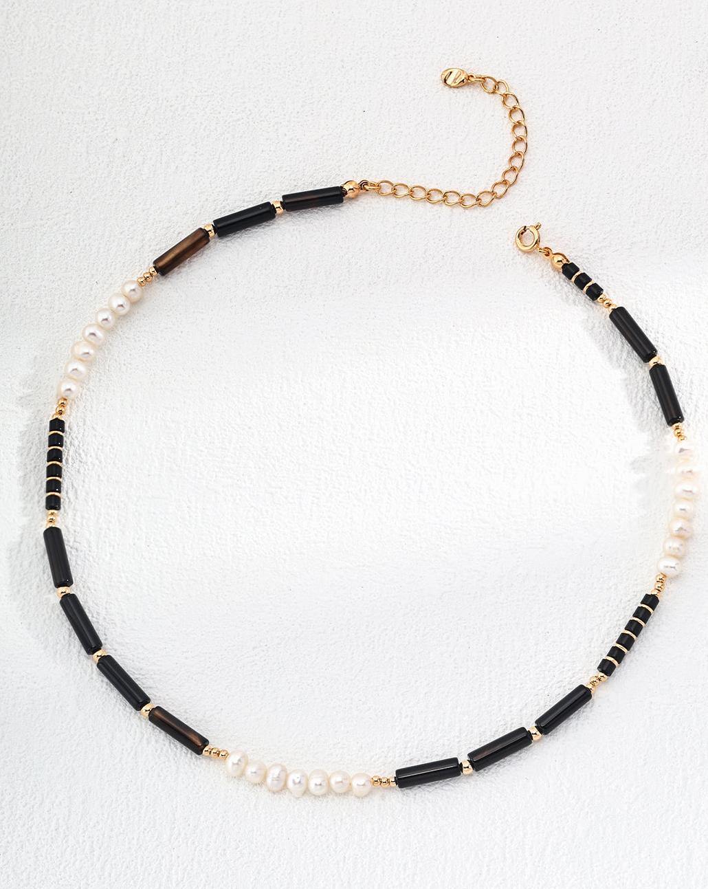 Eclipse Ocean necklace featuring black onyx and natural pearls set in 925 silver with vintage gold finish, showcasing elegance and sophistication.