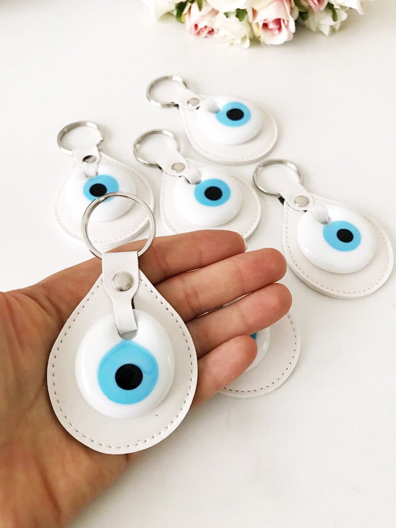 Elegant evil eye leather keychain featuring turquoise and white evil eye beads, perfect for keys or bags.
