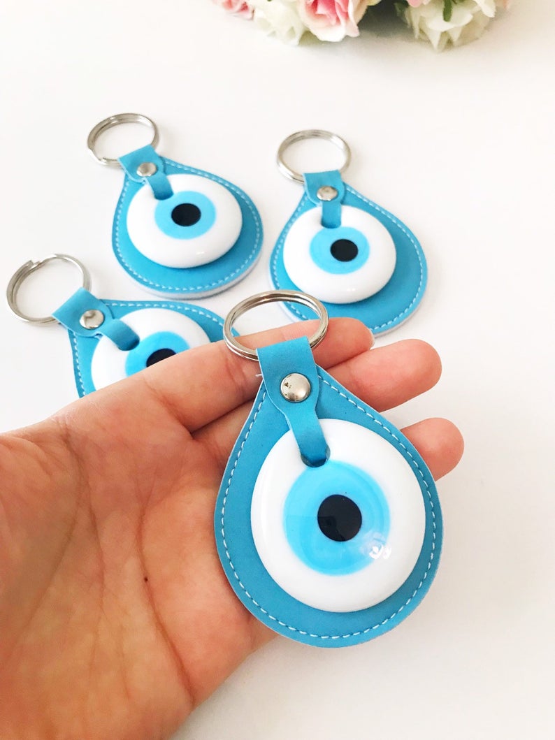 Elegant evil eye leather keychain featuring turquoise and white evil eye beads, perfect for keys or bags.