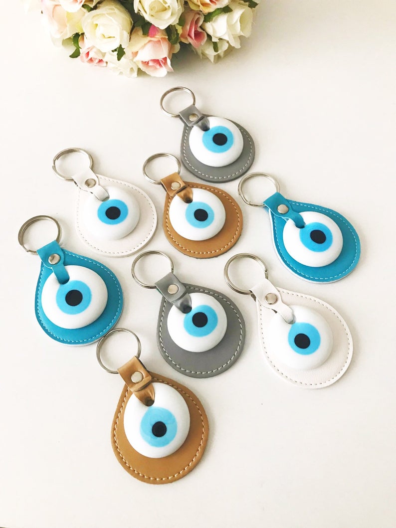 Elegant evil eye leather keychain featuring turquoise and white evil eye beads, perfect for keys or bags.