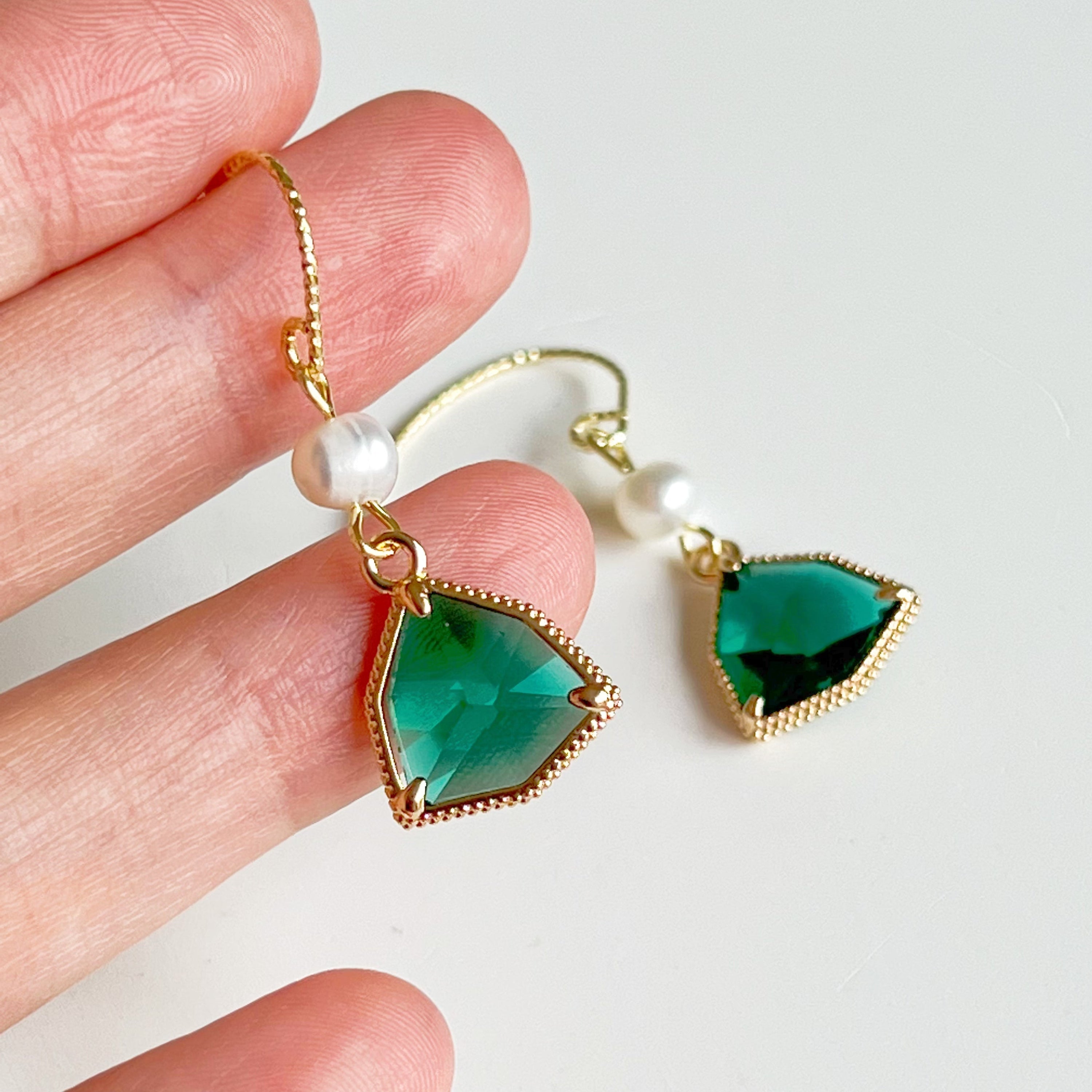 Emerald green crystal and pearl drop earrings featuring gold-plated bronze ear wires and freshwater pearls.