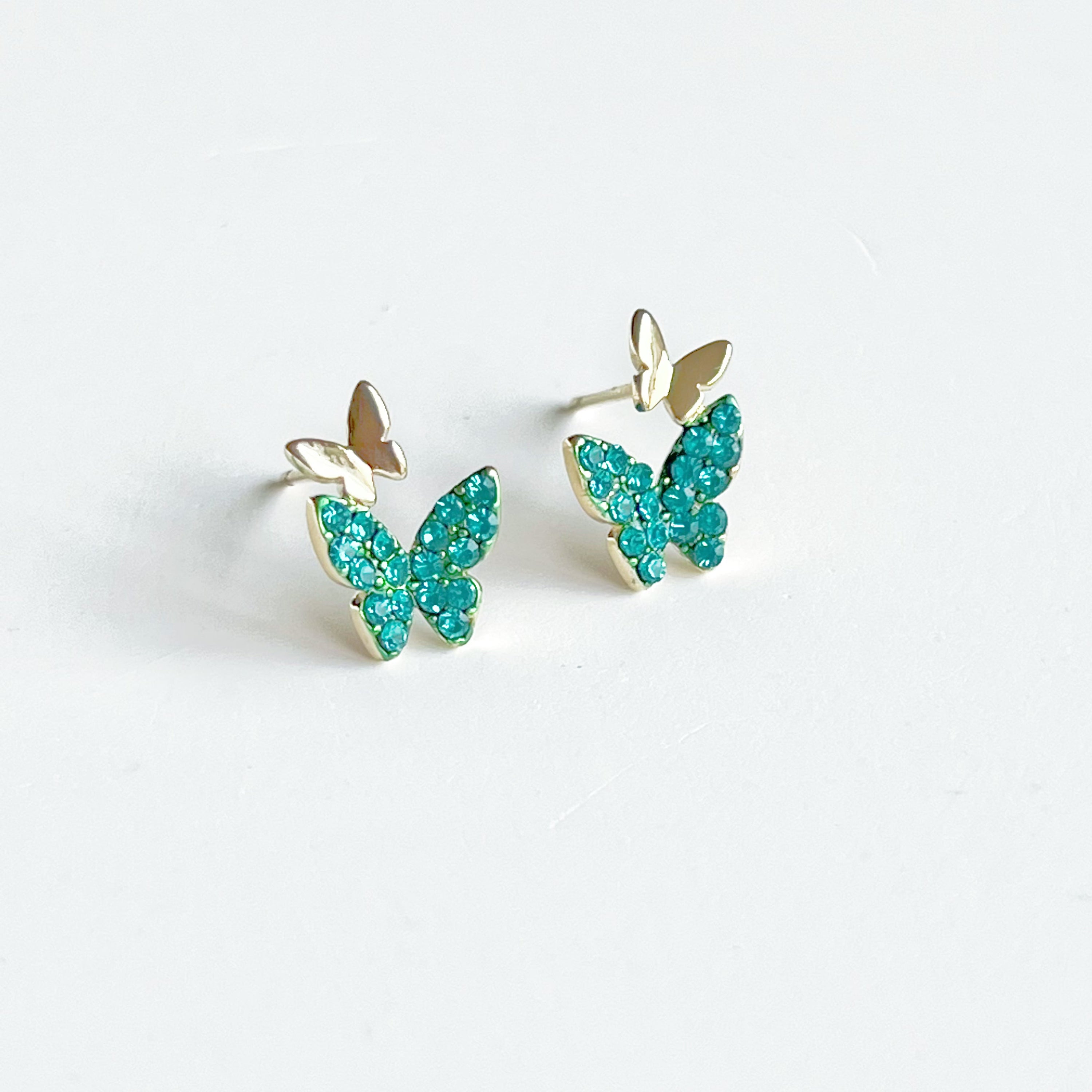 Emerald green crystal butterflies earrings made of gold-plated sterling silver and bronze, featuring sparkling green zircon stones.