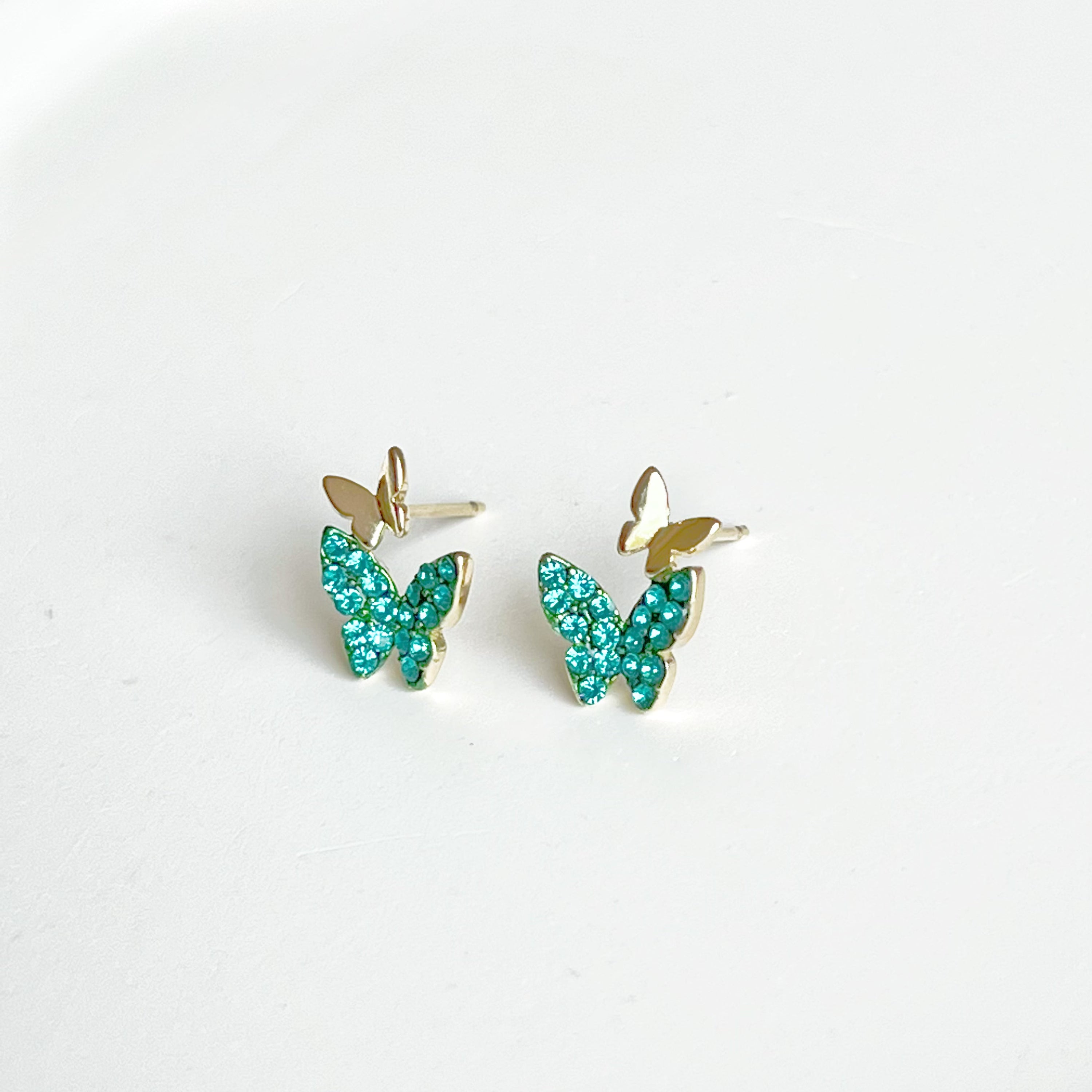 Emerald green crystal butterflies earrings made of gold-plated sterling silver and bronze, featuring sparkling green zircon stones.