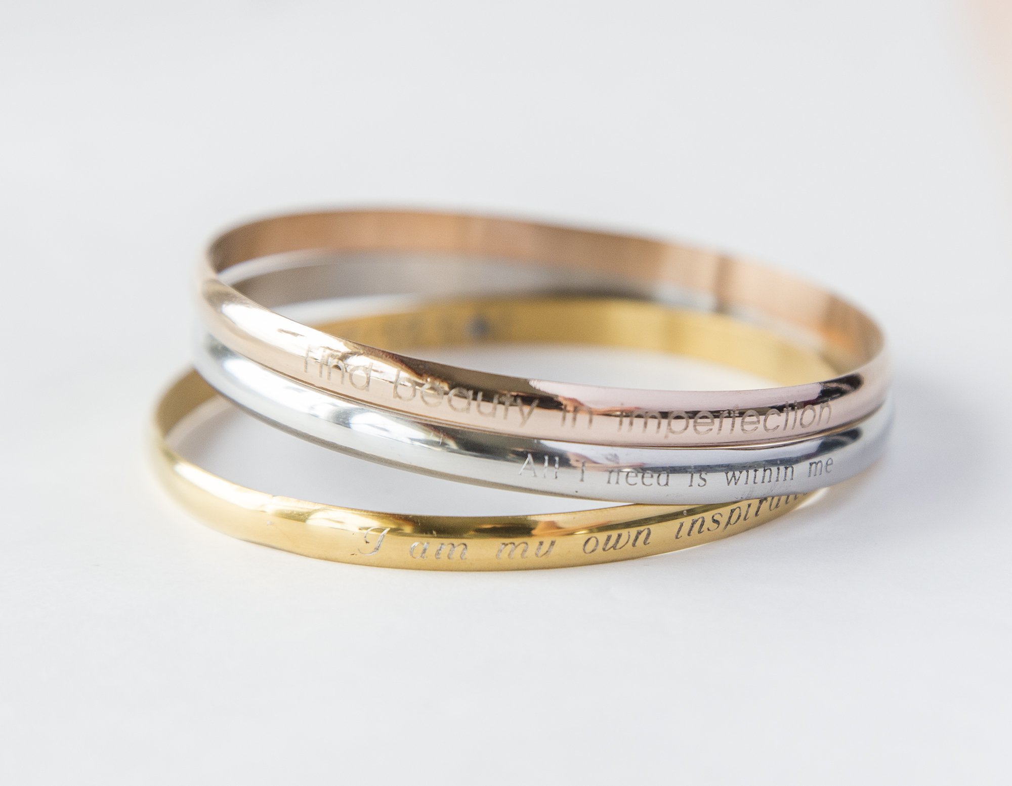 A delicate steel engraved bracelet with a personalized inspirational quote, designed for moms.