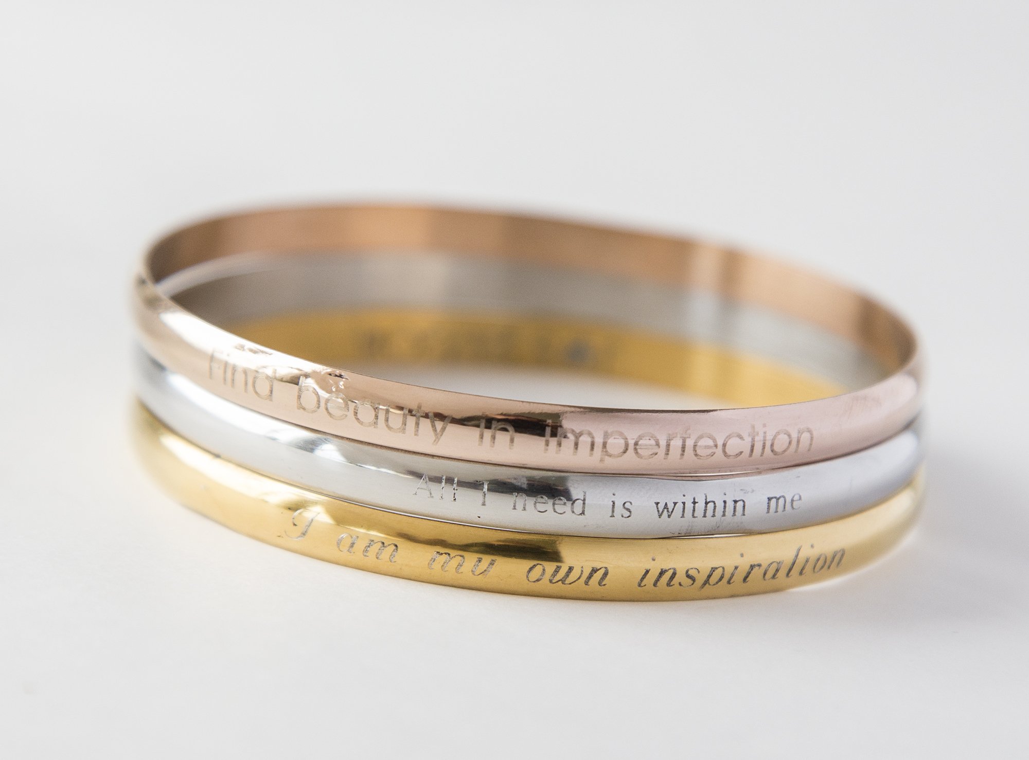 A delicate steel engraved bracelet with a personalized inspirational quote, designed for moms.
