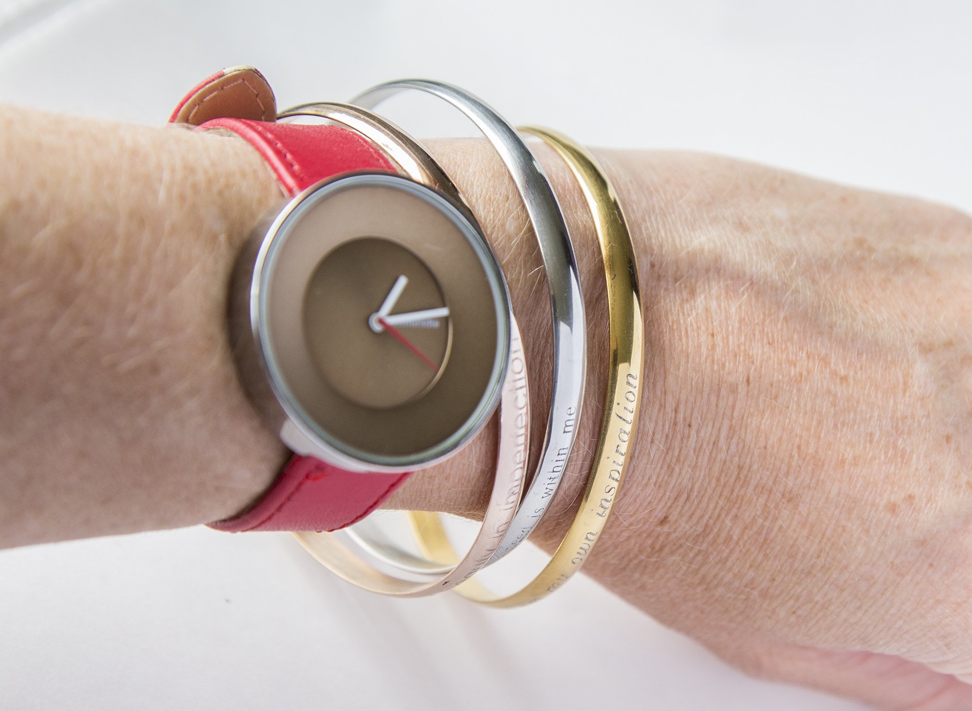 A delicate steel engraved bracelet with a personalized inspirational quote, designed for moms.