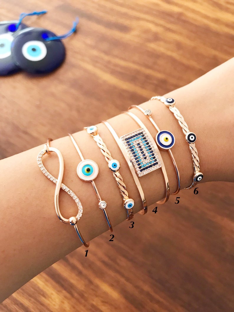 Rose gold Evil Eye Bangle Bracelet featuring a movable oval charm and adjustable cuff design, perfect for everyday wear.