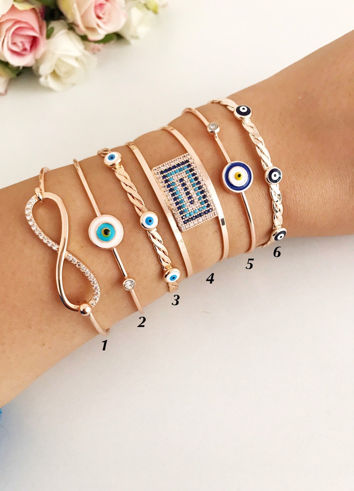 Rose gold Evil Eye Bangle Bracelet featuring a movable oval charm and adjustable cuff design, perfect for everyday wear.