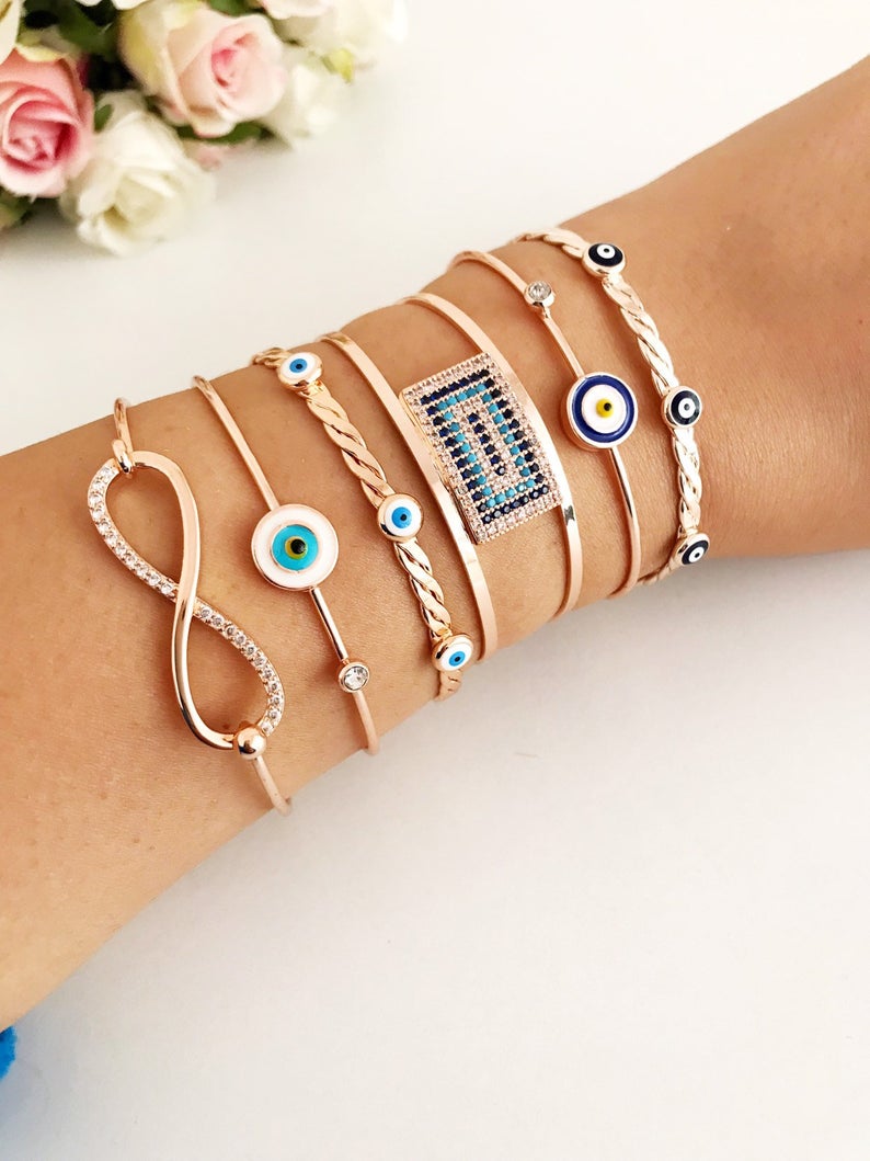 Rose gold Evil Eye Bangle Bracelet featuring a movable oval charm and adjustable cuff design, perfect for everyday wear.