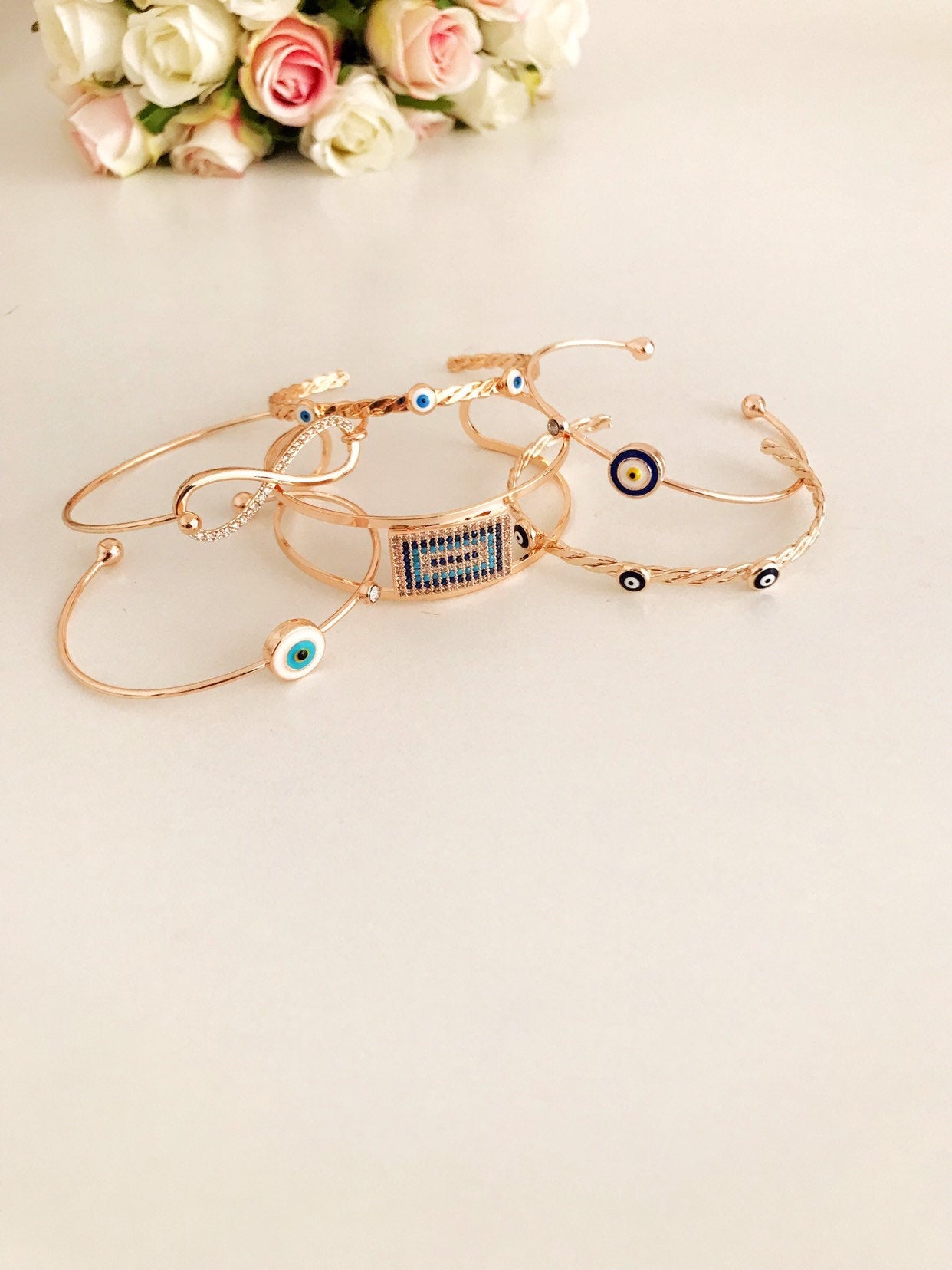 Rose gold Evil Eye Bangle Bracelet featuring a movable oval charm and adjustable cuff design, perfect for everyday wear.
