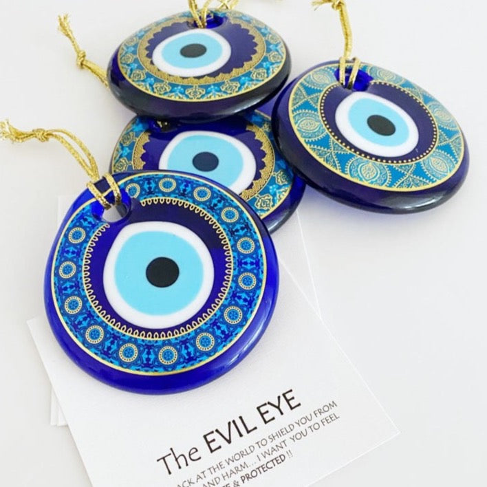 A beautifully hand-painted 7cm Evil Eye bead made of glass, featuring intricate designs in vibrant blue colors, symbolizing protection and good luck.