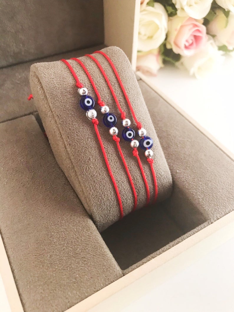 Handmade Evil Eye Bead Bracelet featuring a blue evil eye bead on an adjustable red macramé string.