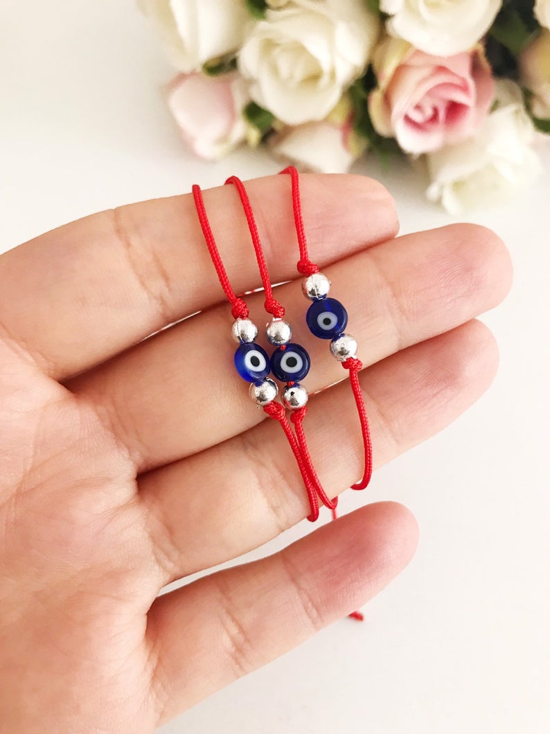 Handmade Evil Eye Bead Bracelet featuring a blue evil eye bead on an adjustable red macramé string.